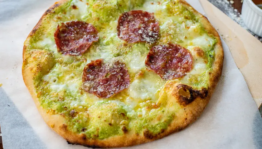 En pizza bianco med salami, ost och grön sås.