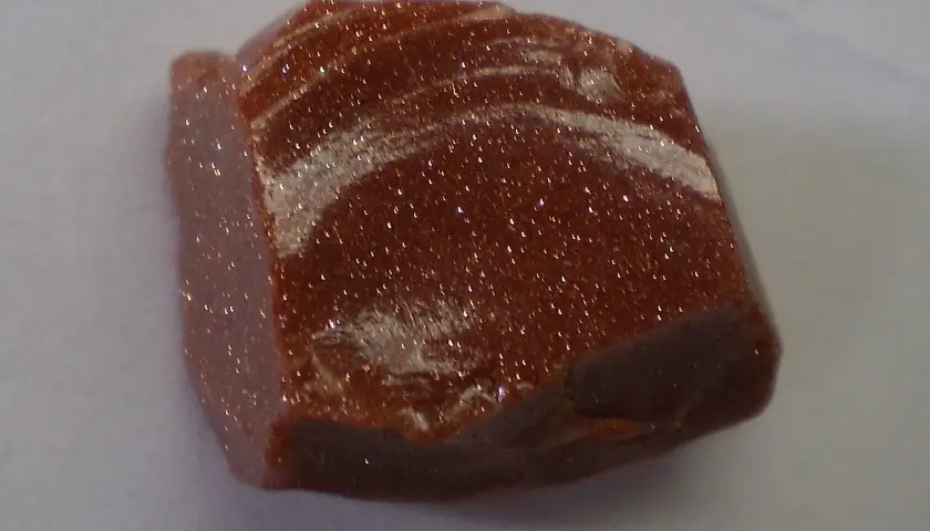 Ein glitzernder goldfluss edelstein mit schimmernden Einschlüssen, der wie ein Sternenhimmel aussieht.