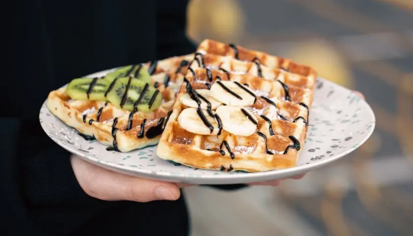 Pyszne gofry belgijskie z bananem i kiwi, polane czekoladą. Idealne na śniadanie, gdy szukasz przepisu na gofry belgijskie.