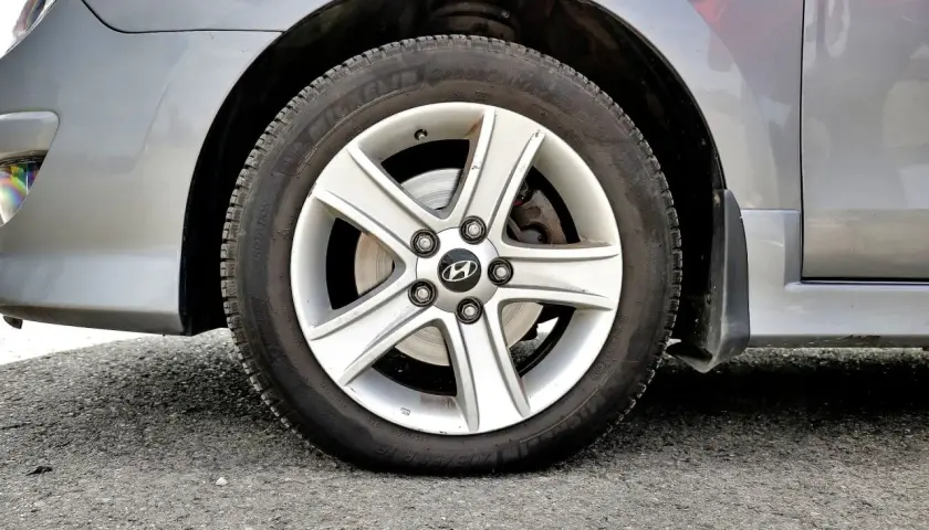 Koło samochodu z widocznym niskim ciśnieniem w oponach. Felga aluminiowa z logo Hyundai.