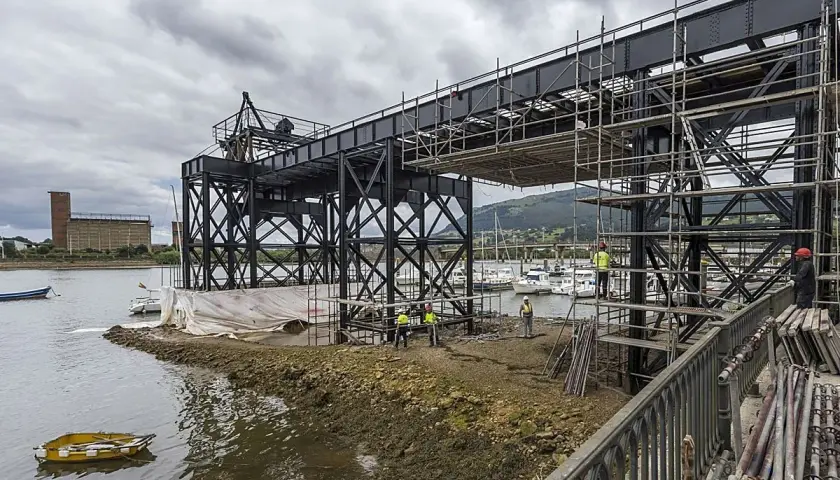 Obras en el puente de Santander, con andamios y trabajadores junto a la ría. Yates amarrados al fondo.