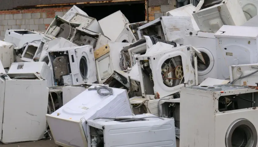 Góra złomu ze starymi pralkami. Zastanawiasz się, co zrobić ze starą pralką? Tutaj znajdziesz odpowiedź – to miejsce na recykling.