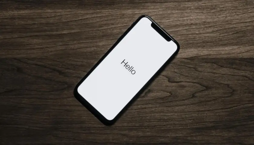 Telefon z napisem "Hello" na białym ekranie. Idealny moment, by pomyśleć, jak zaprosić dziewczynę na randkę.