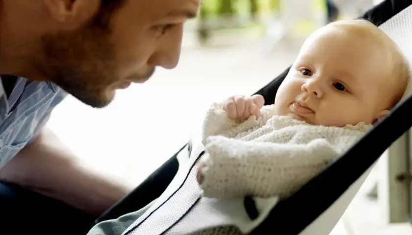 Pappa tittar kärleksfullt på sin bebis i en BabyBjörn babysitter.