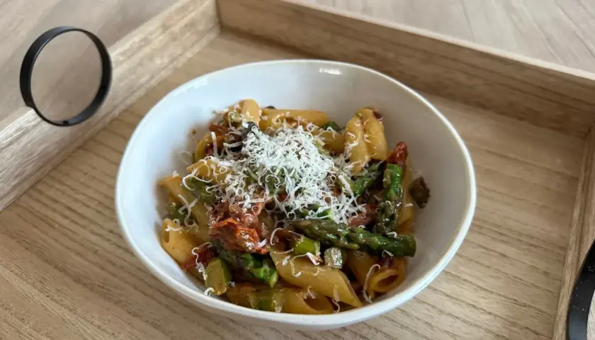 Penne z zielonymi szparagami i suszonymi pomidorami w kremowym sosie, posypane parmezanem. Pyszny makaron ze szparagami w sosie śmietanowym.