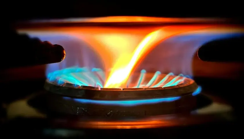 Płomień palnika gazowego, ukazujący jego intensywną temperaturę. Niebieskie i pomarańczowe barwy świadczą o wysokiej temperaturze.