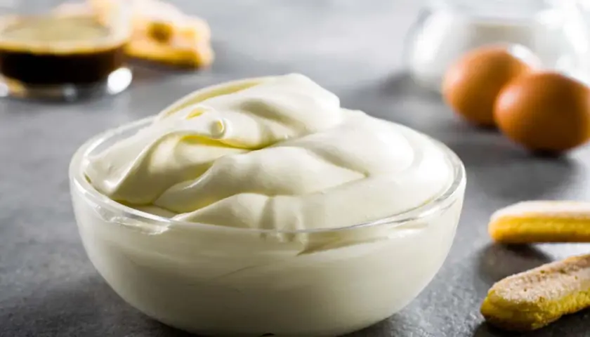 Una ciotola di soffice crema mascarpone pastorizzata, pronta per preparare un delizioso tiramisù con savoiardi, uova e caffè.