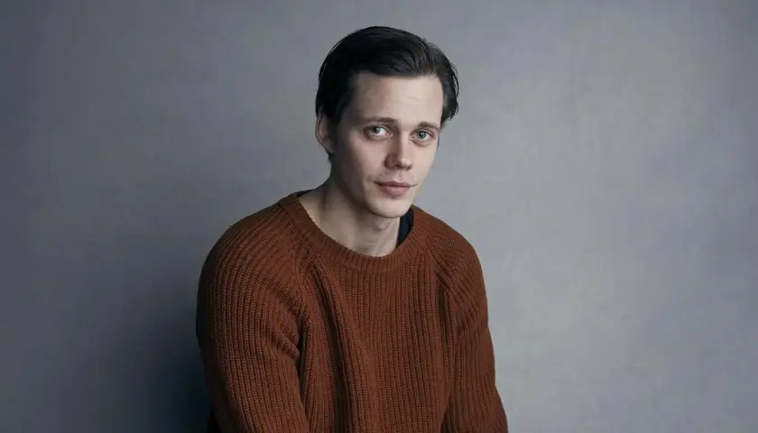 Bill Skarsgård w rudym swetrze, zastanawia się, w jakich filmach grał.