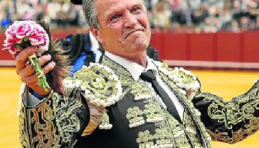 Juan Antonio Ruiz Espartaco, torero con traje de luces, ofrece un ramo de flores al público.