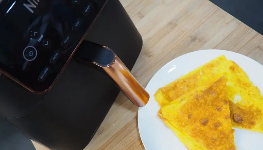 Frittata dorata appena sfornata dalla friggitrice ad aria Ninja, pronta per essere gustata.