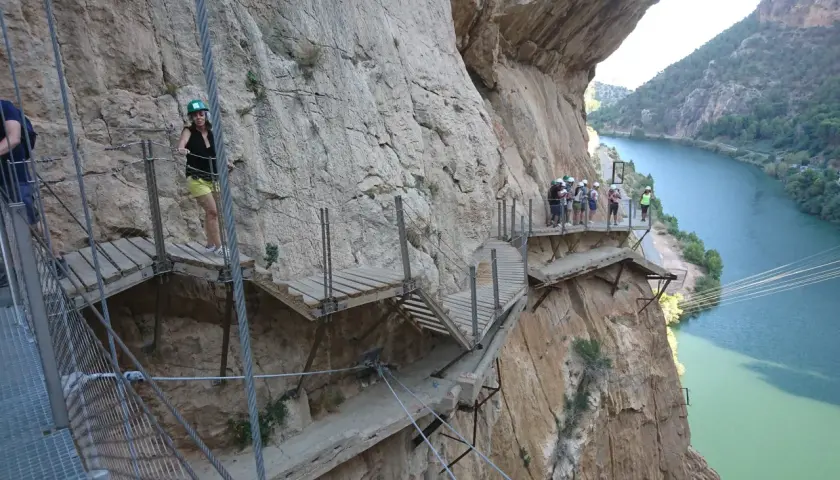 Wagemutige genießen das Malaga Wandern auf dem Caminito del Rey, einem Pfad an steilen Felswänden über einem Fluss.