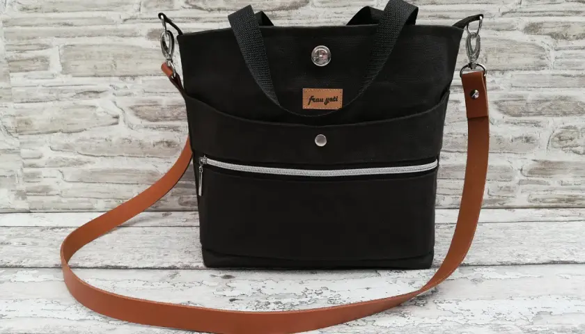 Schwarze Sling Bag mit Lederriemen. Hier findest du ein sling bag schnittmuster kostenlos zum Nachnähen.