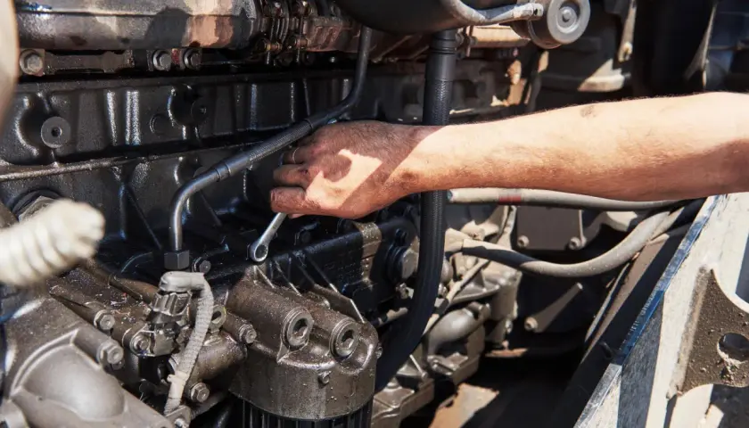 Mano che lavora su un motore, forse per riparare l'alternatore auto.