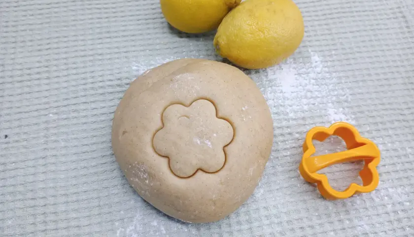 Teig für Canestrini mit Zitronen und Ausstecher in Blumenform.