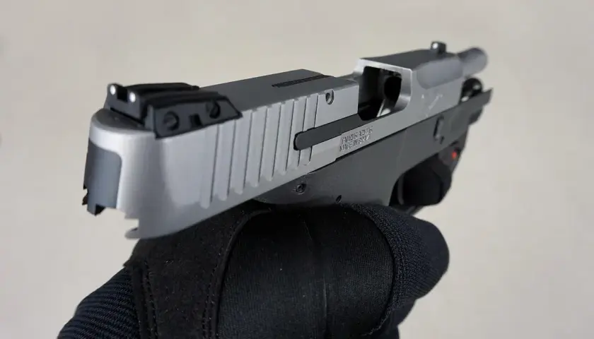 Dłoń w czarnej rękawicy trzyma pistolet. To nie jest najdroższy pistolet na świecie, ale jego precyzja i jakość wykonania budzą podziw.