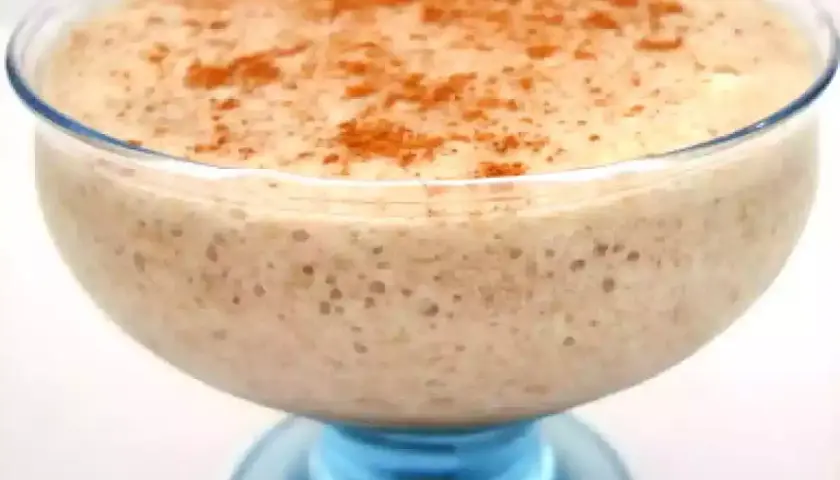 Un déliceux mousse banane crémeuse, saupoudrée de cannelle, servie dans un joli bol en verre bleu.