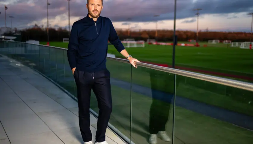 Michael Carrick, jeden z trenerów Man Utd, pozuje na tle boisk treningowych.