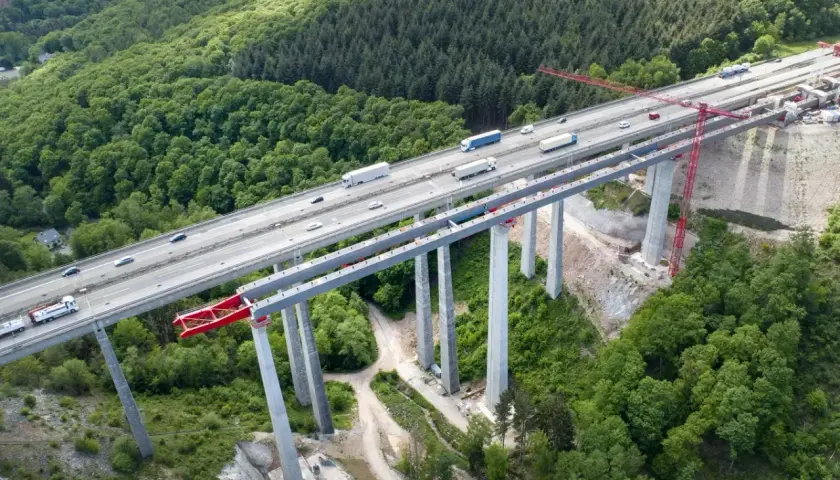 Most autostradowy w budowie, wsparty na filarach z betonu C30/37, otoczony lasem.