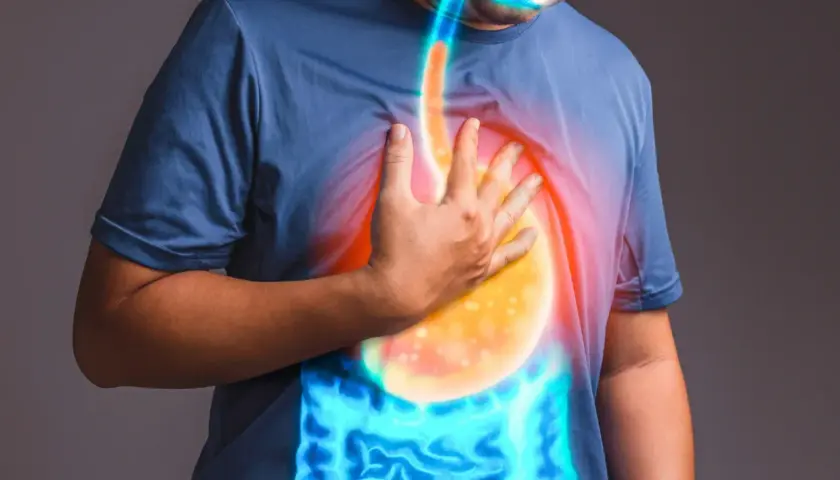 Uomo con mano sul petto, evidenziando il reflusso gastroesofageo e i sintomi legati all'ansia.