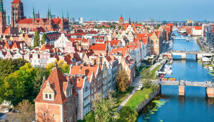 Widok na starówkę Gdańsk z kanałem Motławy, mostami i zabytkowymi kamienicami.