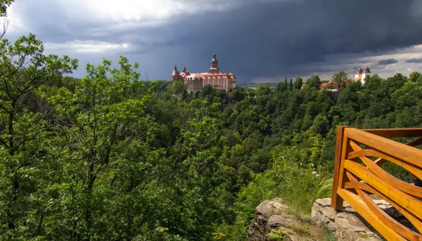 Zamek Książ góruje nad bujną zielenią, zapowiadając burzę. Widok z tarasu widokowego w Książańskim Parku Krajobrazowym.