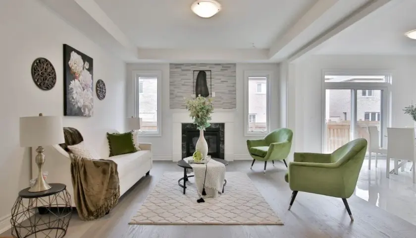 Salon moderne avec canapé blanc, fauteuils verts et cheminée. Une belle idée déco moderne pour un intérieur lumineux.