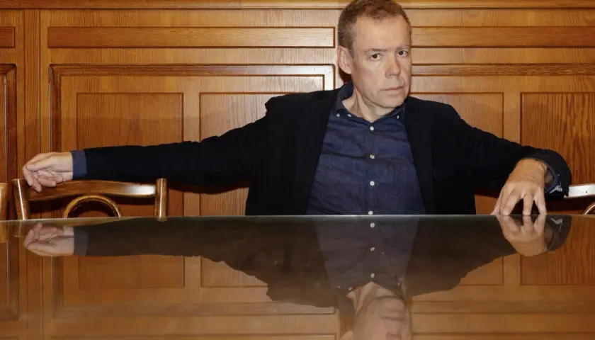 Tony Samuelsson sitter vid ett träbord med en spegelblank yta.