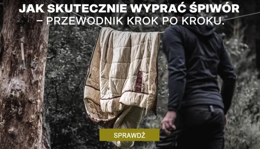 Jak prać śpiwór? Przewodnik krok po kroku. Śpiwór wisi na sznurku, obok stoi osoba w czarnej bluzie.