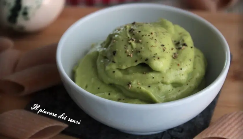 Una cremosa salsa avocado, cosparsa di pepe nero, in una ciotola bianca. Perfetta per accompagnare pasta o come dip.