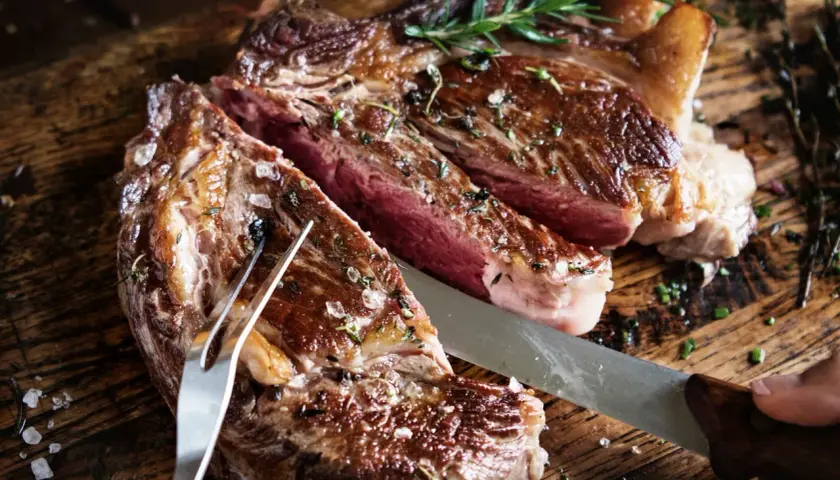 Saftigt bavette steak, perfekt stekt med rosmarin och havssalt, redo att skäras upp på en rustik träskärbräda.