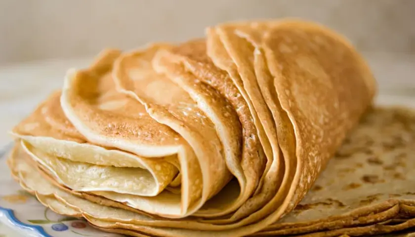 Pile de crêpes dorées, parfaites pour une recette crêpe sans beurre. Elles sont fines et légères, prêtes à être garnies.