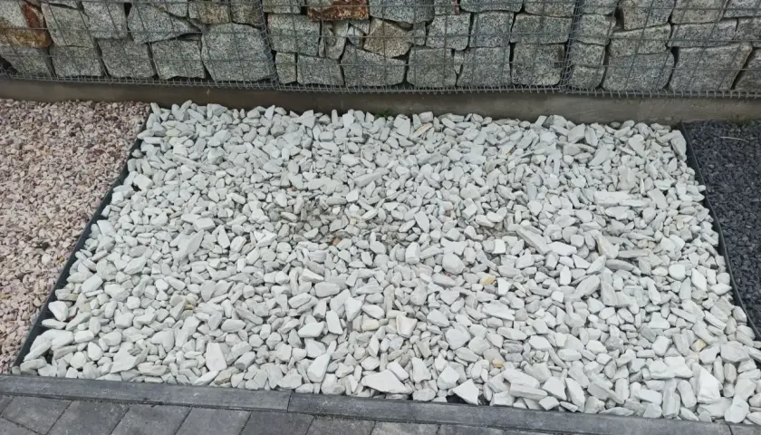 Jasnoszary grys idealny na podjazd. Obok kamienie w kolorze różowym i ciemnoszarym.