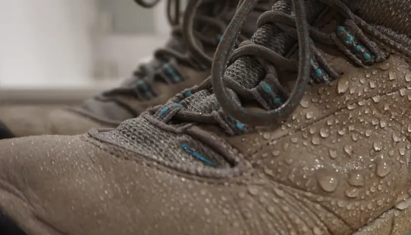 Water droplets on hiking boots. Learn how to clean inside of boots after a muddy adventure.