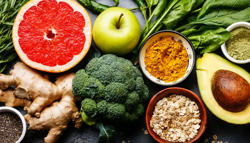 Bunte Auswahl an Lebensmitteln wie Grapefruit, Brokkoli, Avocado, Ingwer und Gewürzen, die wichtige Mineralstoffe liefern.