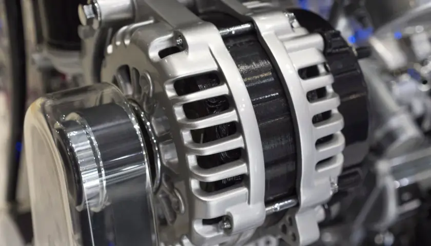 Błyszczący alternator w aucie, kluczowy element układu elektrycznego, gotowy do ładowania akumulatora i zasilania wszystkich systemów pojazdu.