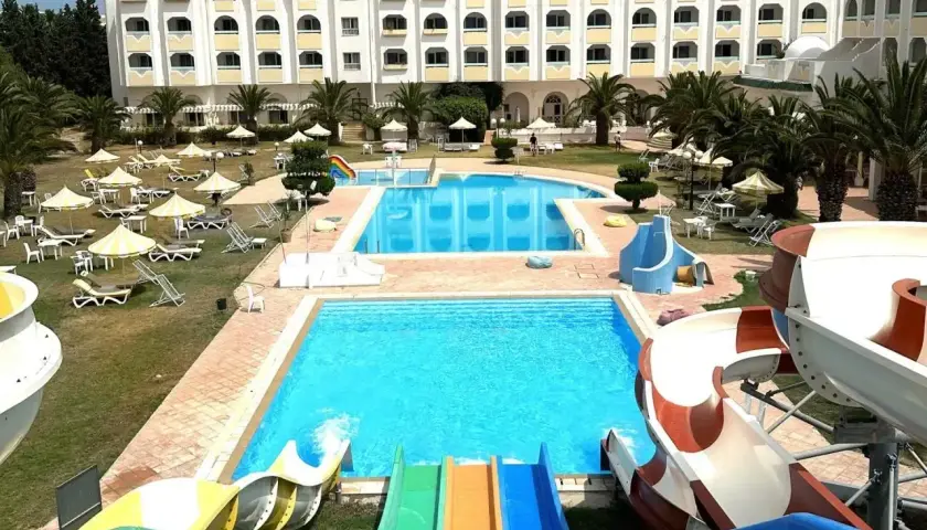 Hotel z basenami i zjeżdżalniami wodnymi w słoneczny dzień.