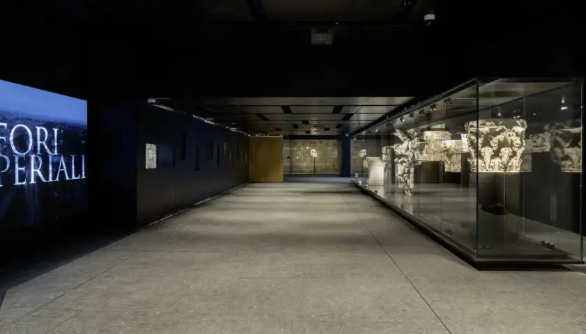 Corridoio moderno con reperti antichi esposti in teche di vetro, un omaggio ai Fori Imperiali, vicino alla metro C Roma Colosseo.