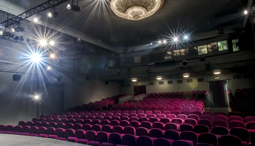 Puste fioletowe fotele w **Teatrze Studio im. Stanisława Ignacego Witkiewicza** czekają na widzów. Reflektory oświetlają scenę.