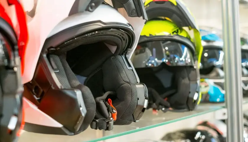 Cascos de moto de varios colores, incluyendo un casco no integral blanco en primer plano, listos para la aventura.