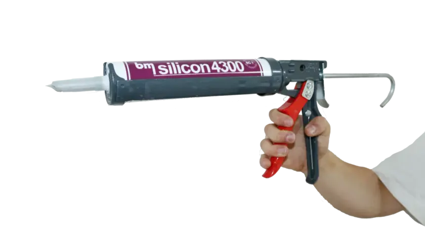 Hand hält eine Kartuschenpistole mit "bm silicon 4300" für das acryl dichtmasse entfernen.