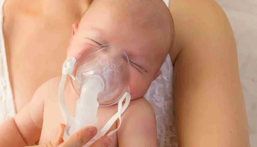 Bambino con maschera per inalazione, un aiuto per la tosse.