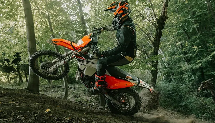 Motociclista en KTM salta en un sendero boscoso. ¡Las últimas ktm noticias sobre enduro!