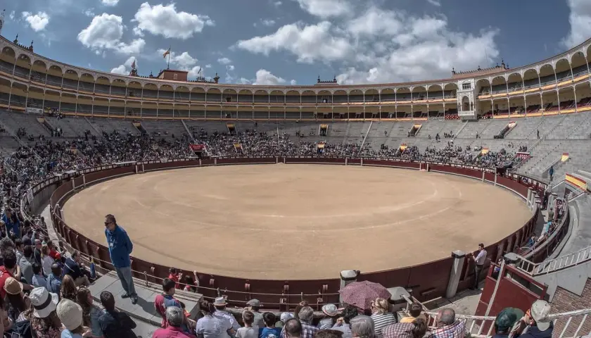 Espectadores en la plaza de toros, la plaza más grande de España, bajo un cielo azul con nubes.