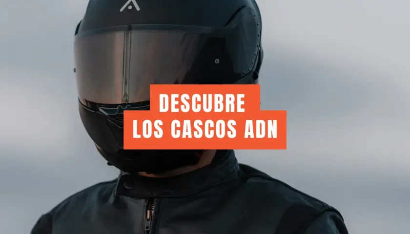 Motociclista con casco integral negro y chaqueta de cuero. El texto dice "DESCUBRE LOS CASCOS ADN". Un casco jet prohibido para esta aventura.