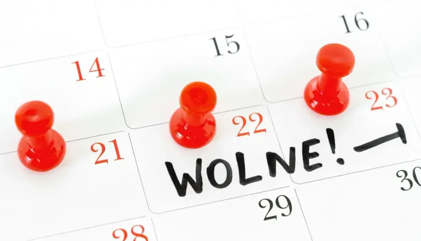 Kalendarz z zaznaczonymi czerwonymi pinezkami dniami i napisem "WOLNE!".