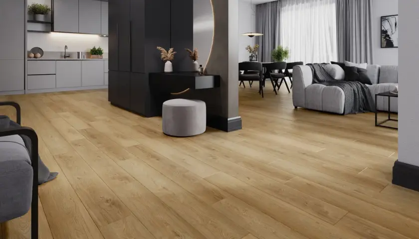 Jasne, drewnopodobne panele laminowane czy winylowe tworzą ciepłą bazę dla nowoczesnego wnętrza z szarą kuchnią i salonem.