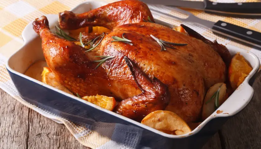 Un délicieux filet de poulet au barbecue, doré et juteux, servi avec des quartiers d'orange et des pommes de terre rôties.