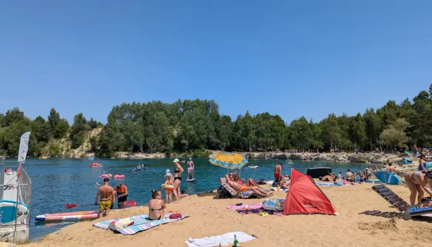 Słoneczny dzień nad zalewem Balaton Trzebinia. Ludzie odpoczywają na plaży, pływają i relaksują się w wodzie.