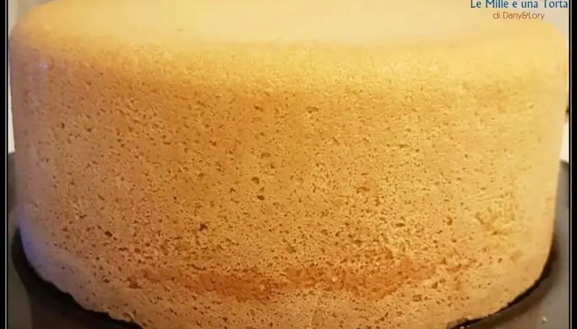 Un pan di spagna sofficissimo, dorato e invitante, pronto per essere farcito. La sua consistenza perfetta promette un dolce delizioso.
