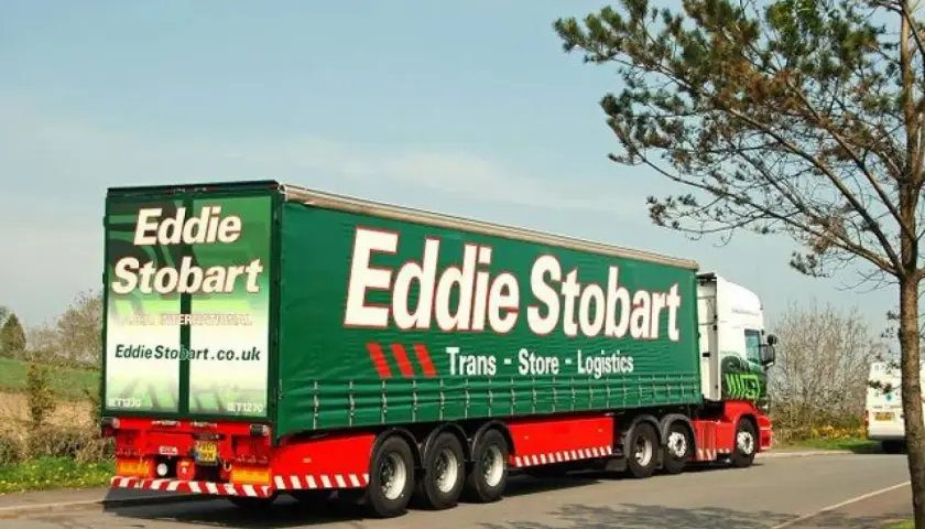 Ein Eddie Stobart Sattelzug, ein typisches Beispiel für was ist ein Sattelzug, fährt auf einer Straße.
